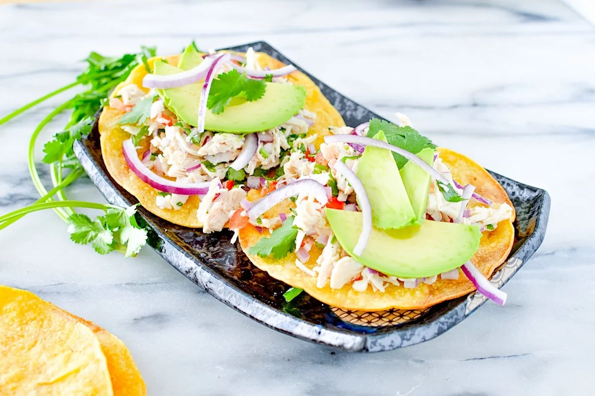 Tostadas topped with rotisserie chicken, avocado, mint and radishes.