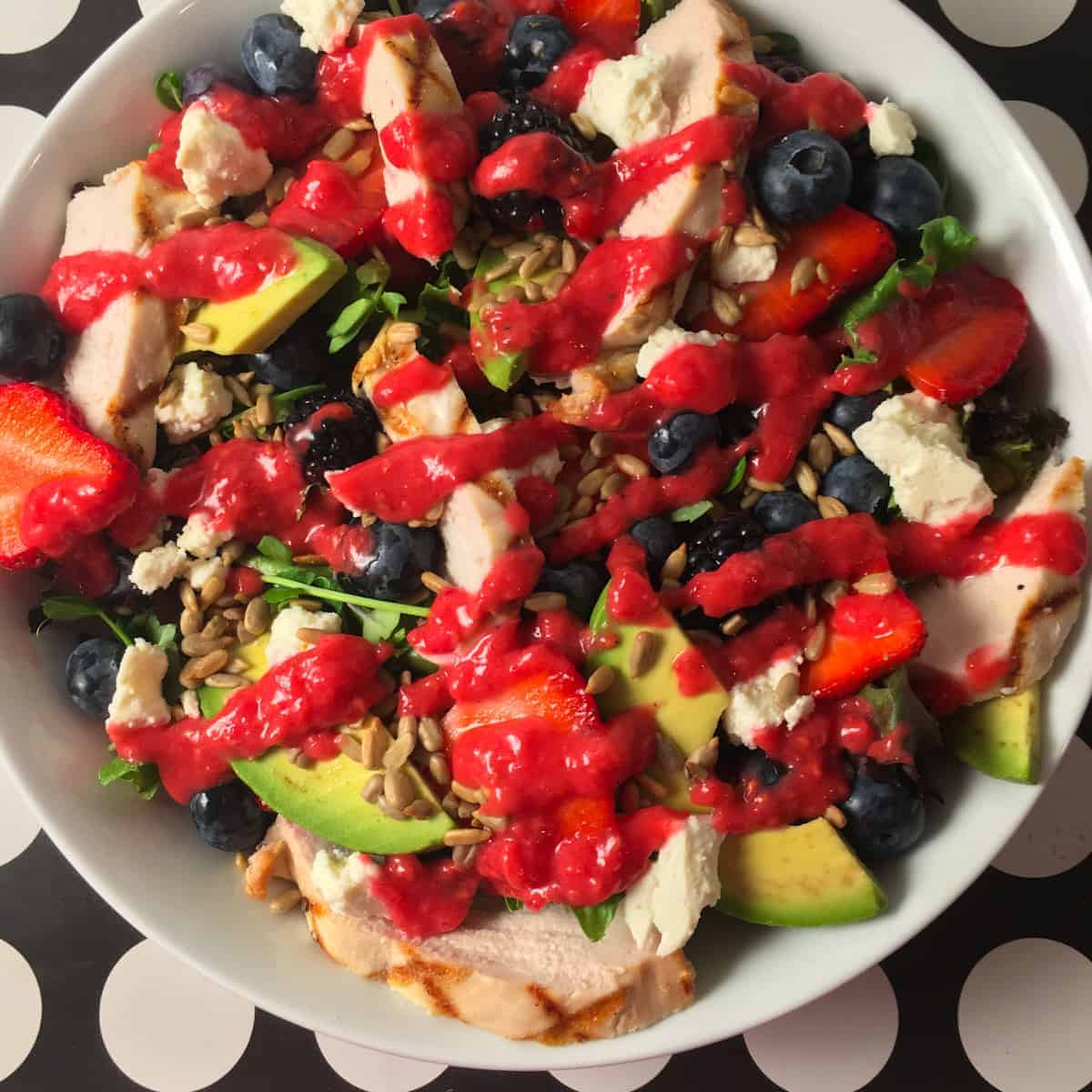 Rotisserie chicken with strawberries, raspberries, black berries and avocado topped with raspberry vinaigrette.