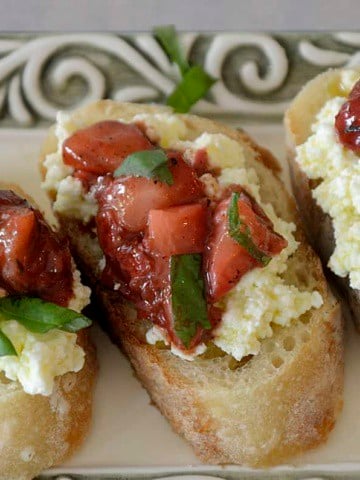Three crostinis topped with homemade ricotta and strawberry balsamic compote.