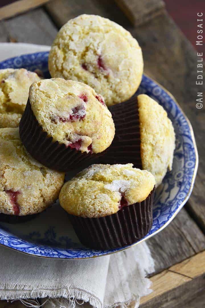 Plate of Lemon muffins with strawberries in brown liners.