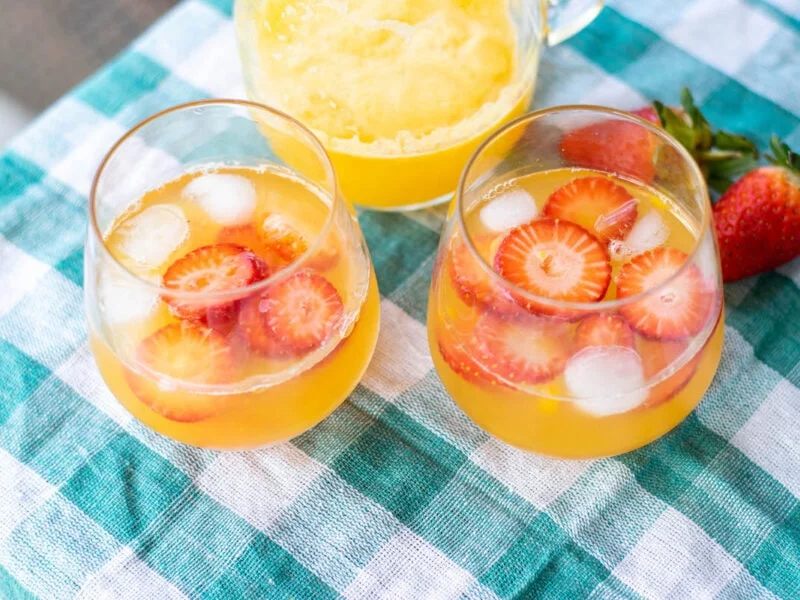 Glasses of Mango Lemonade with strawberry slices.