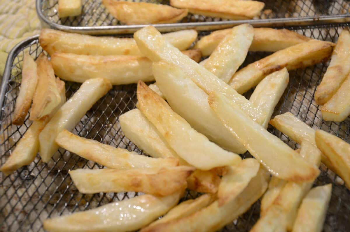 Golden crispy salt and vinegar fries on a wire rack.