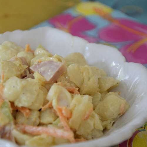 Close up of creamy pasta salad with ham, pineapple, grated carrot, celery and greenn onion.