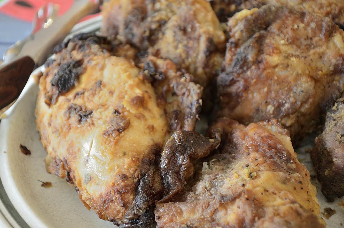 Close up of breaded air fried pickle brined chicken on a platter.