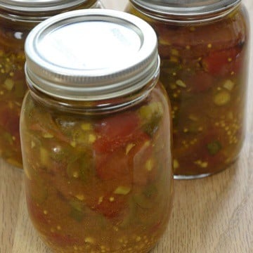 Jars of pickled tomatoes with jalapenos, onions, oil and spices.