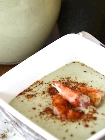 Chilled avocado soup with lobster and chili lime seasoning garnish.