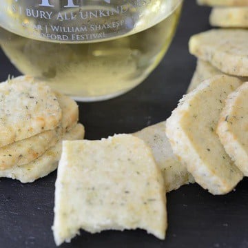 Glass of Chardonnay with savoury lemon thyme shortbread cookies scattered around it.