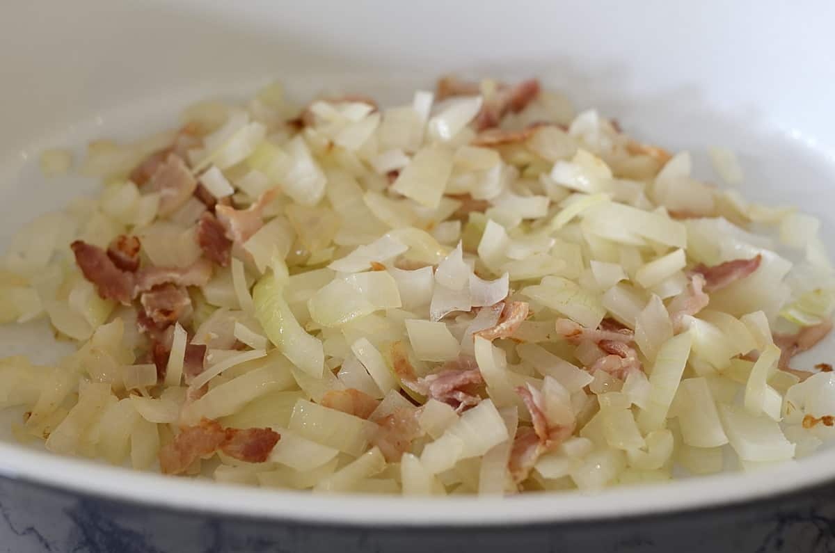 Sauteed bacon and onion in baking pan.
