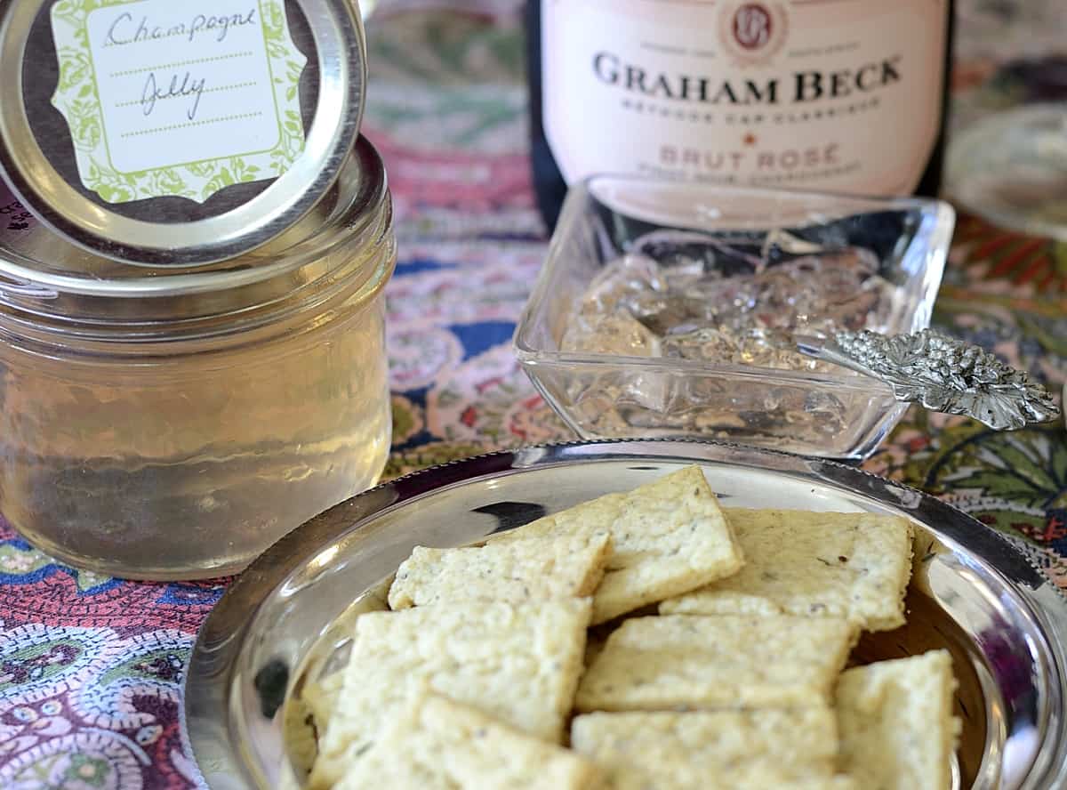 Close up of Champagne Crackers on a silver dish with Champagne Jelly behind.