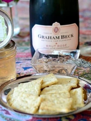 Close up of Champagne Crackers on a silver dish with Champagne Jelly behind.