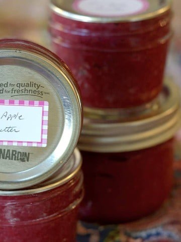 Jars of Cranapple Butter stacked with labels.