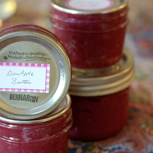Jars of Cranapple Butter stacked with labels.
