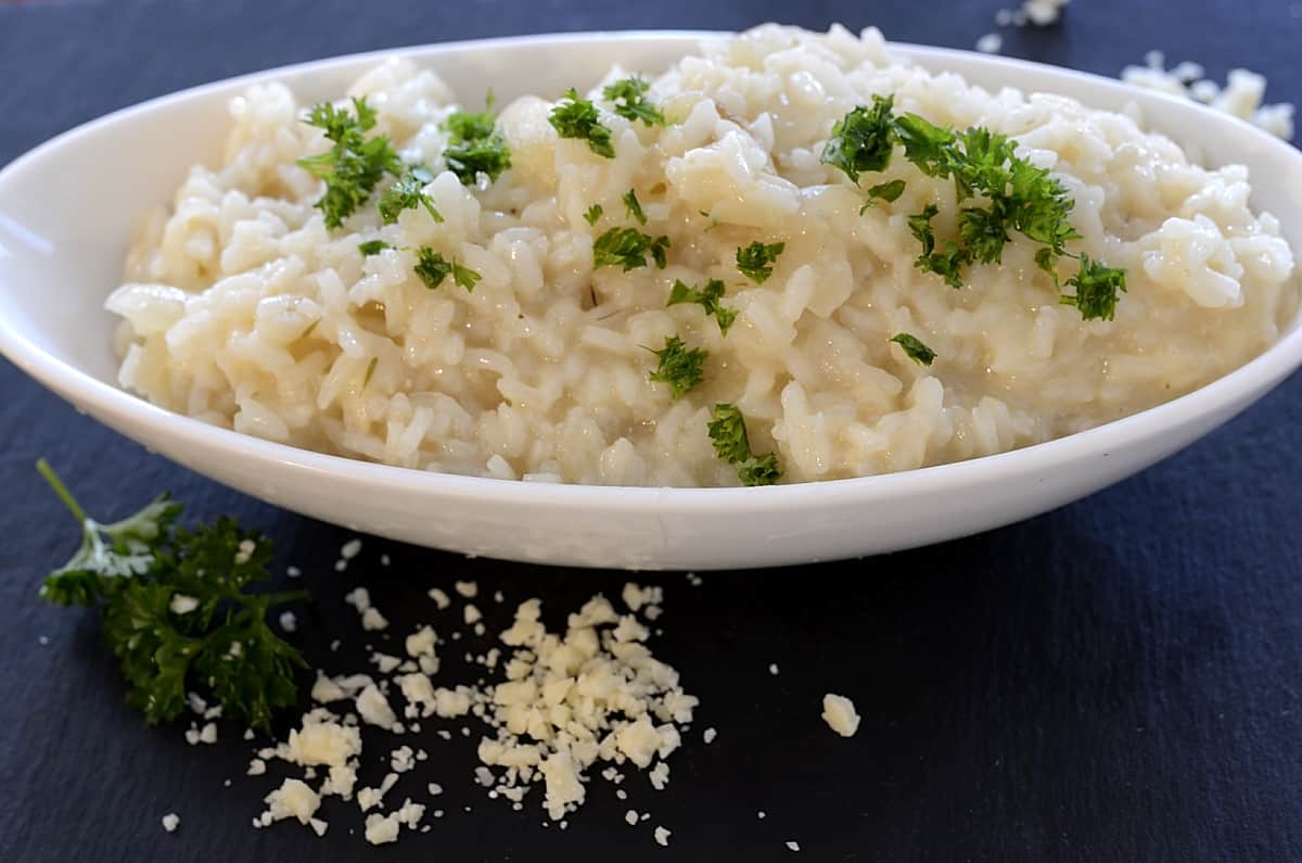 Champagne risotto in a serving dish garnished with parsley.