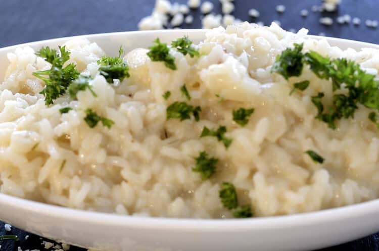 Champagne risotto in a serving dish garnished with parsley.