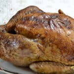 Close up of golden brown turkey, cooked from frozen, on a serving platter.