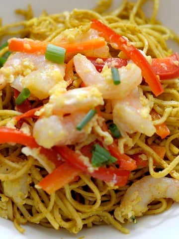 Curried Singapore Noodles with shrimp and red peppers in a bowl.