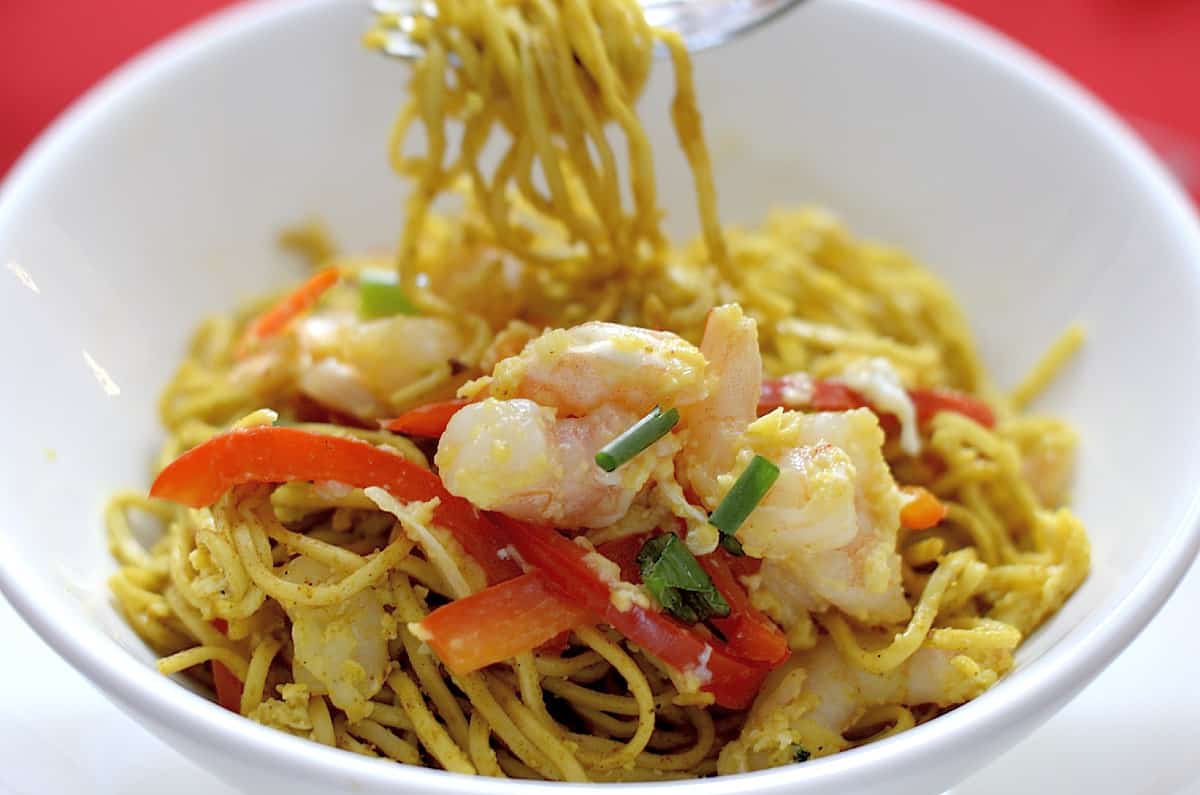 Curried Singapore Noodles with shrimp and red peppers in a bowl.