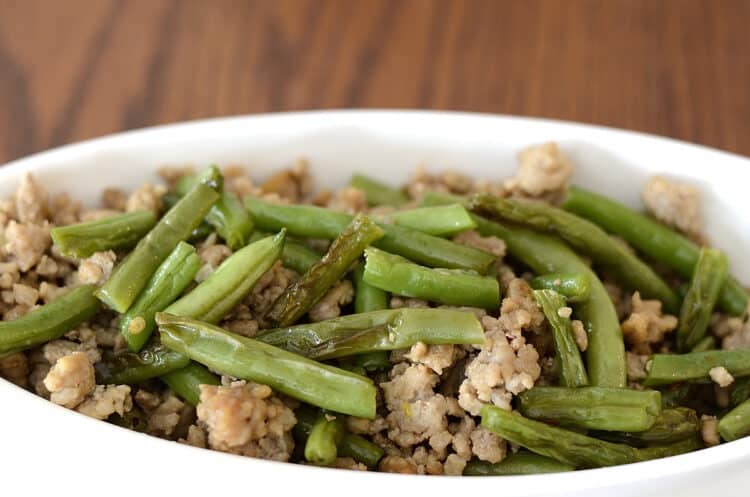 Schezuan fried green beans with ginger ground pork in a dish.