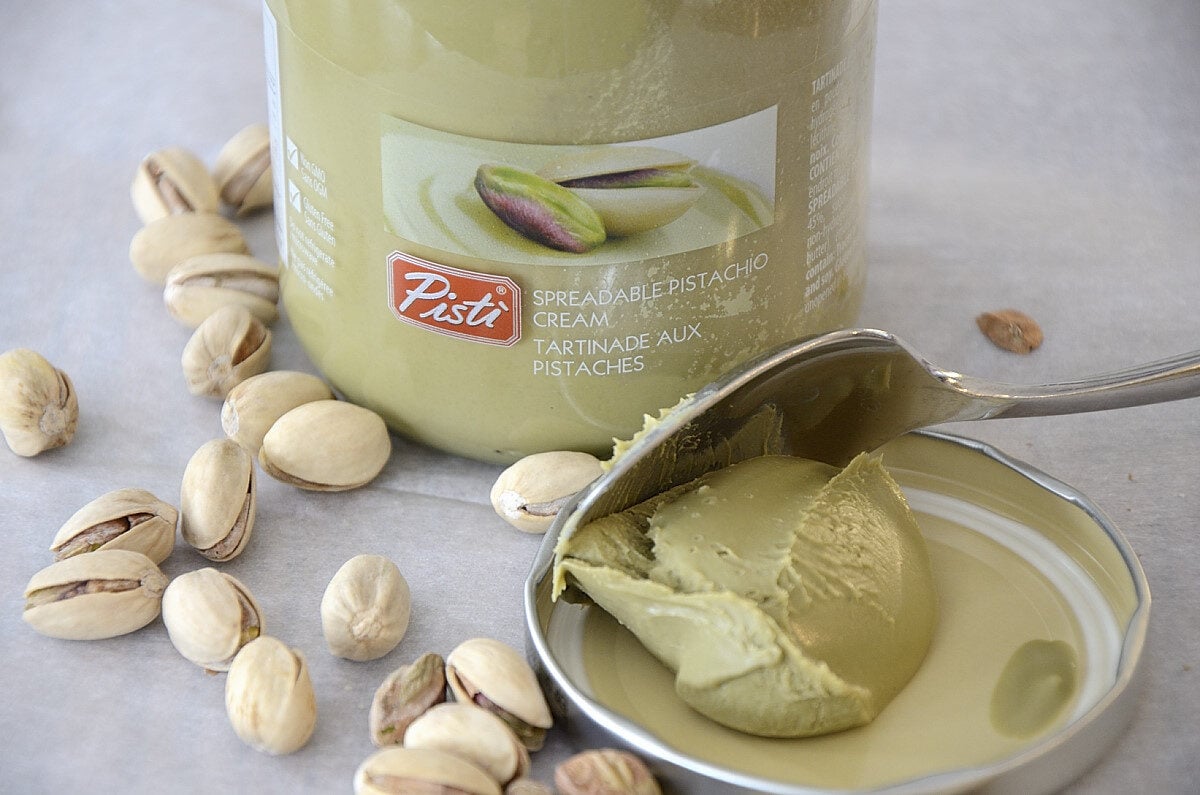 Jar of Pisti pistachio cream with a scoop on the side.