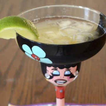 Frosty lime, tequila and beer mix over ice in a funny margarita glass.
