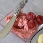 Raspberry butter in a small dish with a spreader.