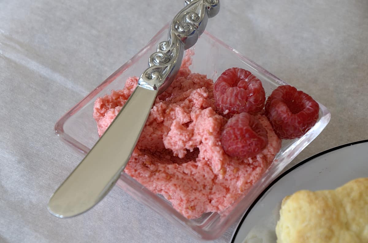 Raspberry butter in a small dish with a spreader.