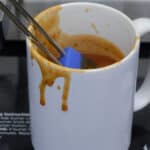 A mug of Simple Barbeque Sauce with a silicone brush standing up in it.