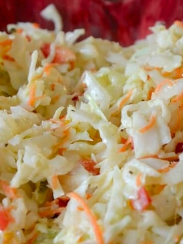 Close up of Dolly Parton Coleslaw with cabbage, onion, carrot and red pepper.