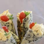 Four Sesame appetizer cones filled with Shrimp Mousse supported in a martini glass.