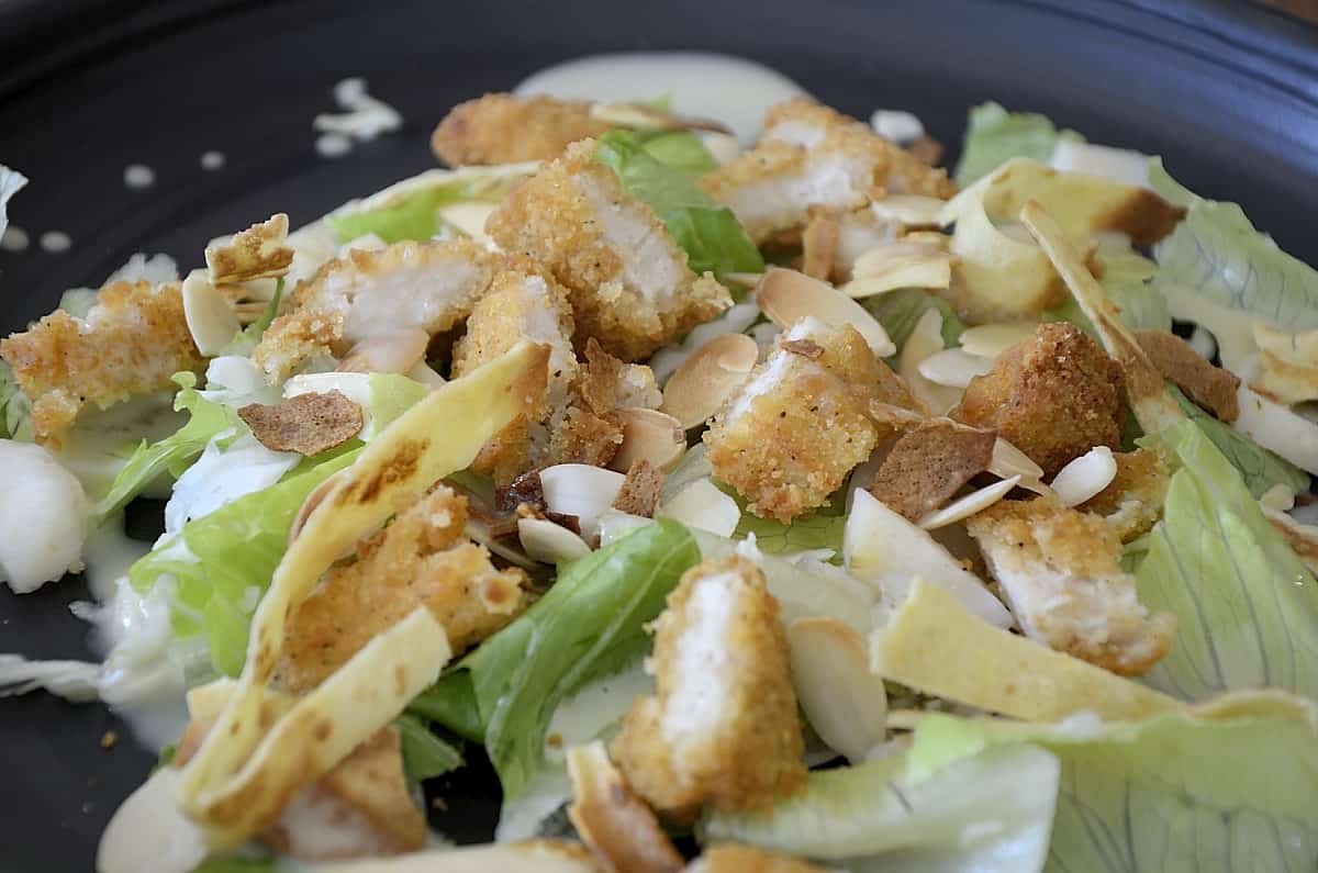 Copy Cat Applebee's Chicken Tenders Salad with toasted almonds, crunchy cabbage and chow mein noodles over a bed of lettuce.