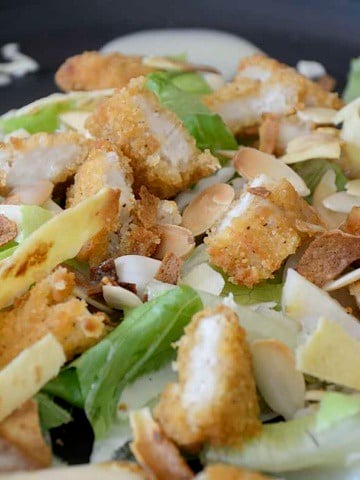 Copy Cat Applebee's Chicken Tenders Salad with toasted almonds, crunchy cabbage and chow mein noodles over a bed of lettuce.