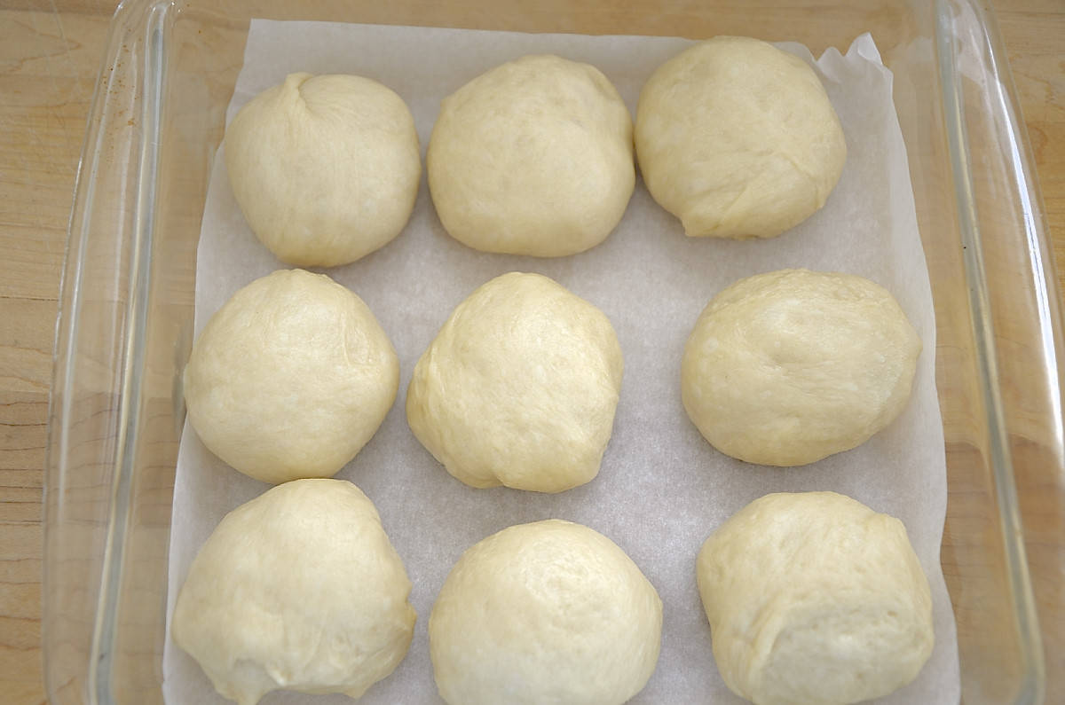 Dough for sweetened condensed milk buns shaped and in baking pan.