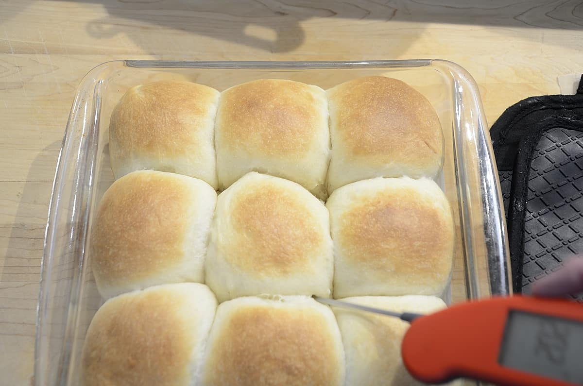 Baked sweetened condensed milk buns with an instant read thermometer.