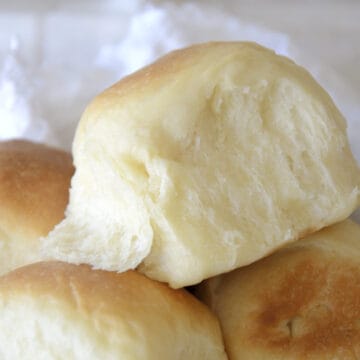 Baked sweetened condensed milk buns piled in a basket.