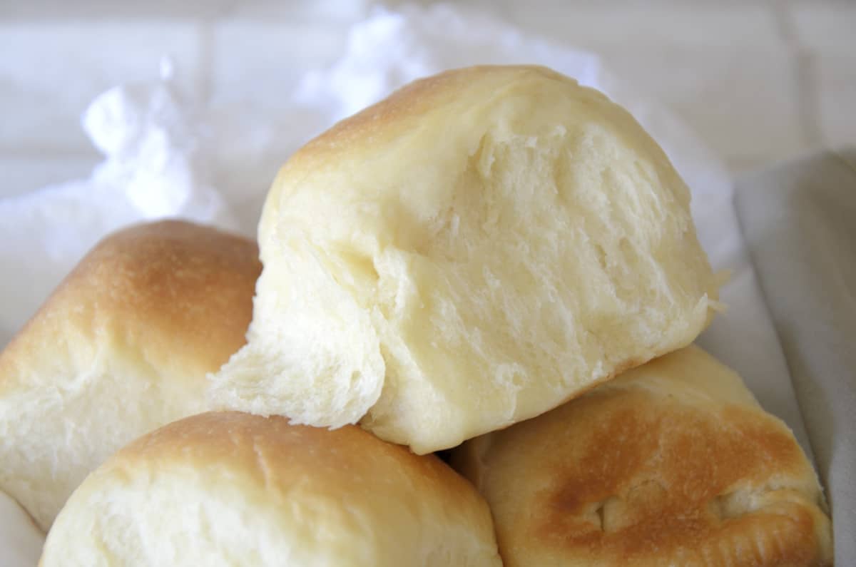 Baked sweetened condensed milk buns piled in a basket.